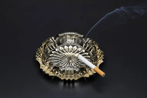 Burning cigarette with smoke in ashtray — Stock Photo, Image