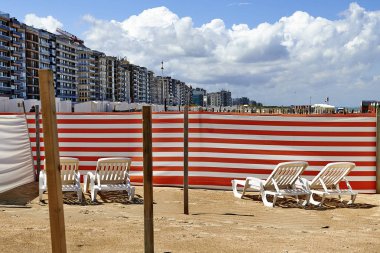 Rüzgardan korunan Belçika kıyısında uzun sandalye
