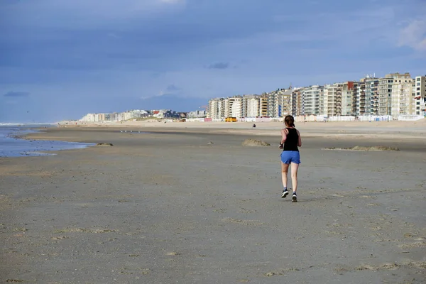 Vrouw joggen op het strand — Stockfoto