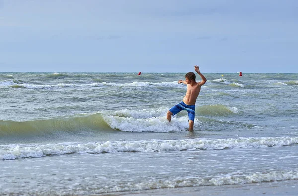 Giovane ragazzo godendo di giocare con l'acqua — Foto Stock