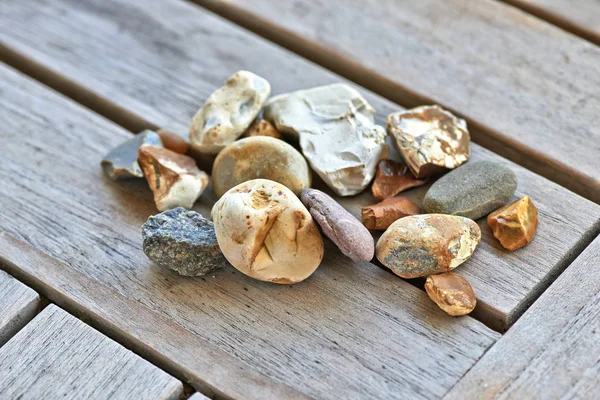 Veel kleine stenen op houten tafel — Stockfoto