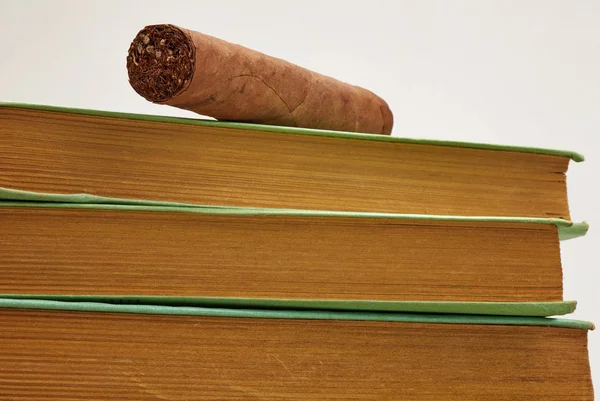 Sigaro cubano marrone posato su una pila di vecchi libri — Foto Stock