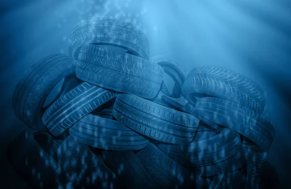 Old black tires polluted deep blue sea — Stock Photo, Image