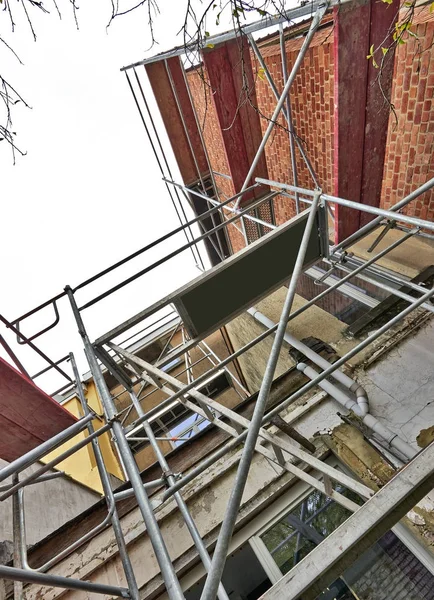 Byggnadsställningar på terrass mot smutsiga och grunge vägg — Stockfoto