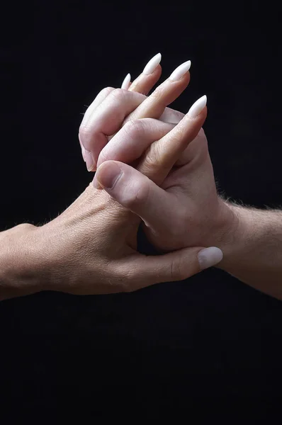 Mannelijke en vrouwelijke handen samen op zwarte achtergrond — Stockfoto