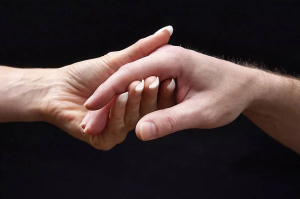 Mannelijke en vrouwelijke handen samen op zwarte achtergrond — Stockfoto