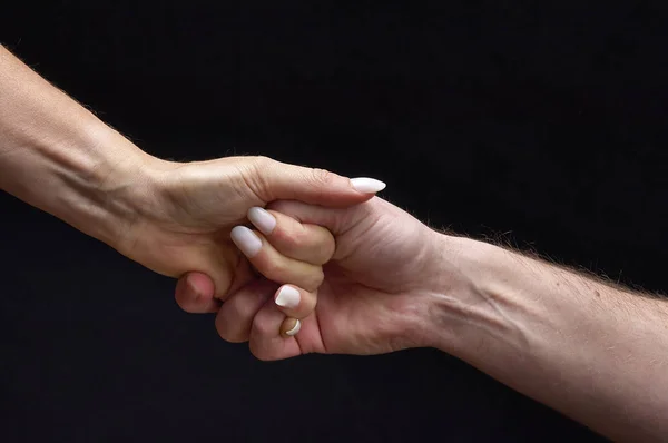 Mãos masculinas e femininas juntas no fundo preto — Fotografia de Stock