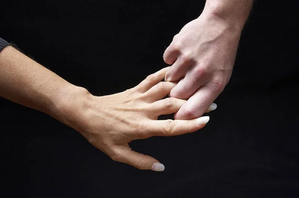 Mãos masculinas e femininas juntas no fundo preto — Fotografia de Stock