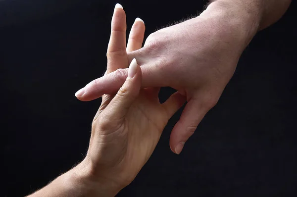 Mannelijke en vrouwelijke handen samen op zwarte achtergrond — Stockfoto