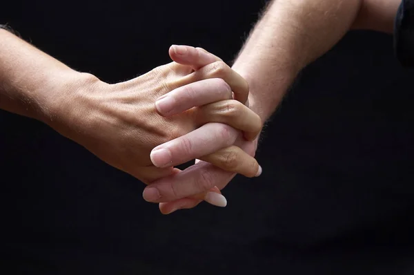 Male and female hands together on black background — Stock Photo, Image