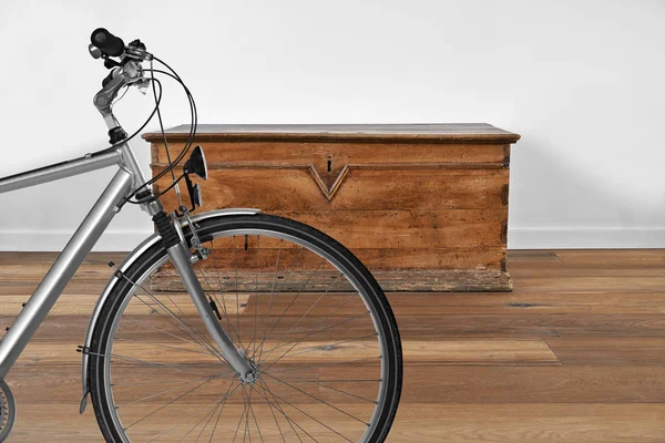 Интерьер с винтажным деревянным сундуком и велосипедом на переднем плане — стоковое фото