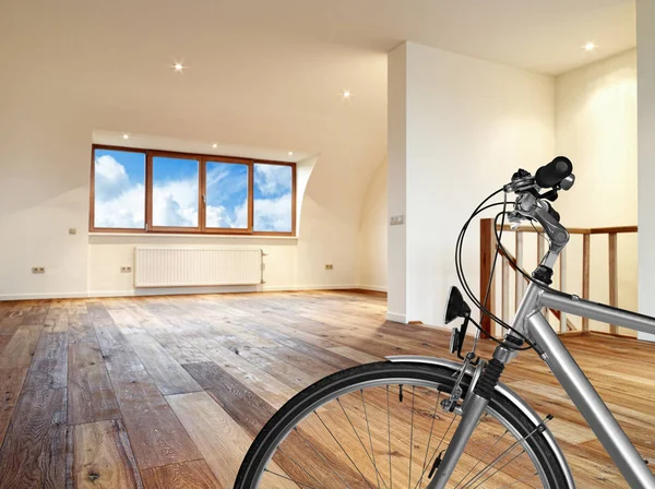 Interiér s dřevěnou podlahou a kolo v popředí — Stock fotografie