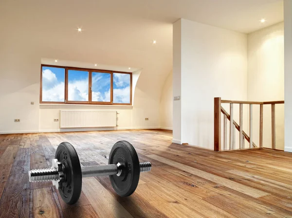 Interior with wooden floor and dumbbells in foreground — Stock Photo, Image