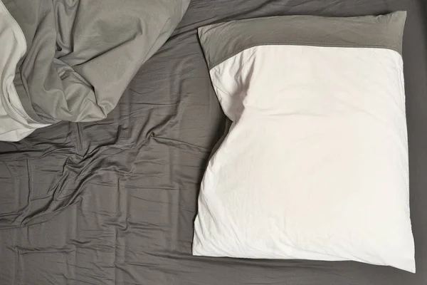 Disheveled sheets and pillows of an unmade bed — Stock Photo, Image