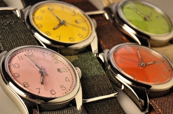 Cuatro relojes de colores en perspectiva y baja profundidad de campo —  Fotos de Stock