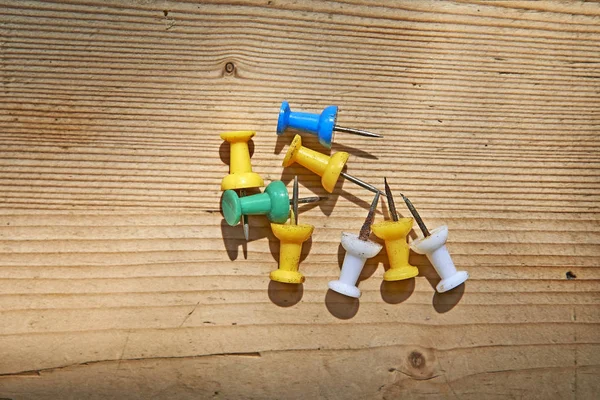 Colorful rusty pushpins on wooden board — Stock Photo, Image