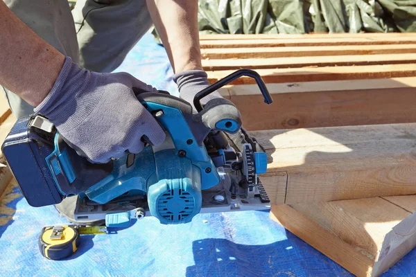 Kék galléros carpenter segítségével elektromos fűrész — Stock Fotó
