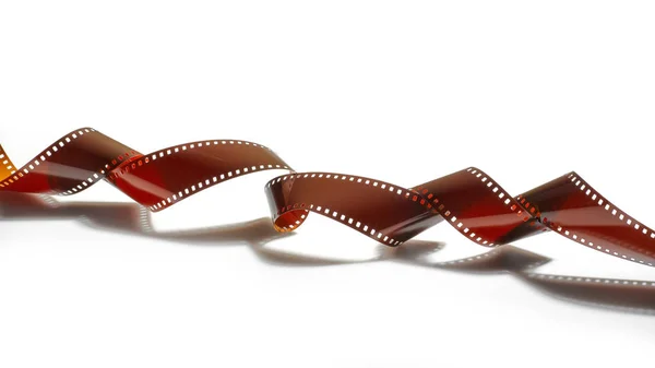 Spirale curva di un film striscia 35mm e la sua forte ombra — Foto Stock