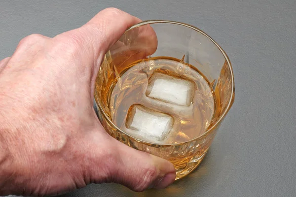 Mano maschile prendere un bicchiere di whisky — Foto Stock