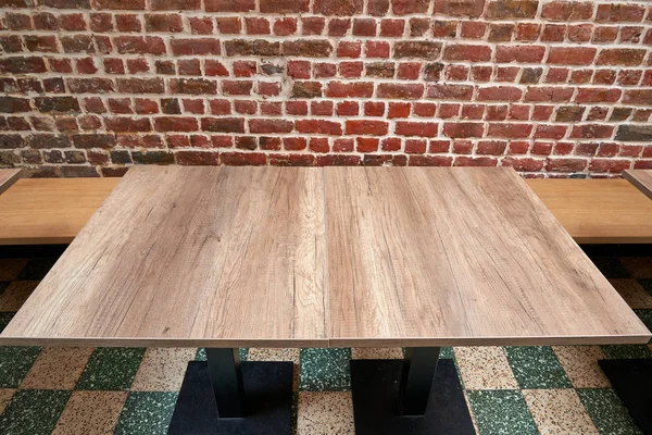 Niza mesa de madera rústica contra la pared de ladrillo rojo —  Fotos de Stock