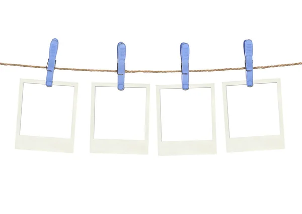 Cuatro pinzas de plástico y marco instantáneo en la cuerda — Foto de Stock