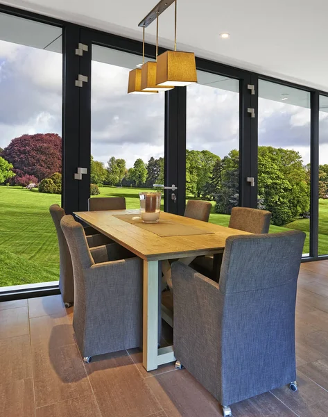 Elegante e luxuosa mesa de jantar com grandes janelas — Fotografia de Stock