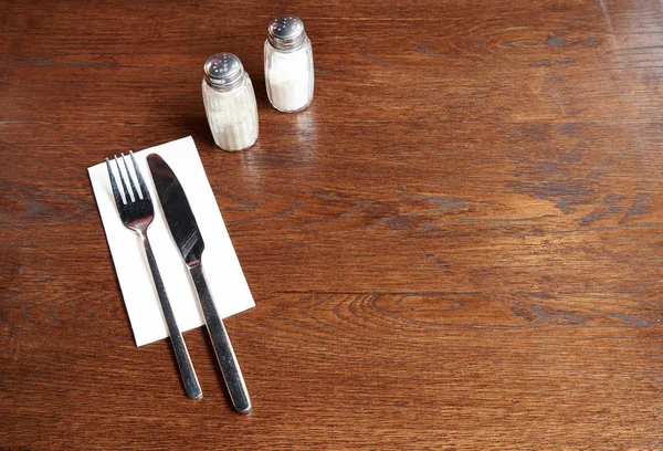 Silverware with salt and pepper on a rustic pub table — 스톡 사진