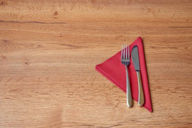 Tekstil yatağı ve çatal bıçak takımı ahşap masa üzerine