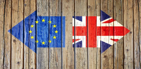 Deux flèches avec des drapeaux peints sur une clôture en bois. Concept de Brexit — Photo