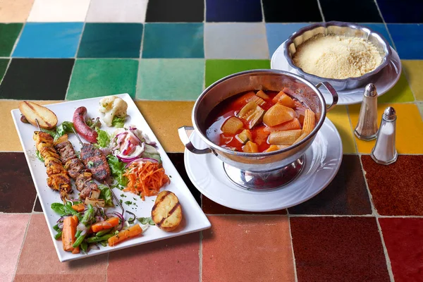 MoroccanCouscous y carnes a la parrilla en la mesa de mosaico de colores — Foto de Stock