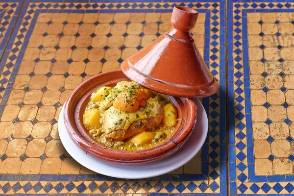 Moroccan chicken tajine on colorful mosaic table — Stock Photo, Image