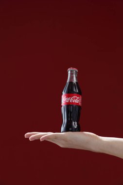 Hand holding bottle of Coca-Cola clipart