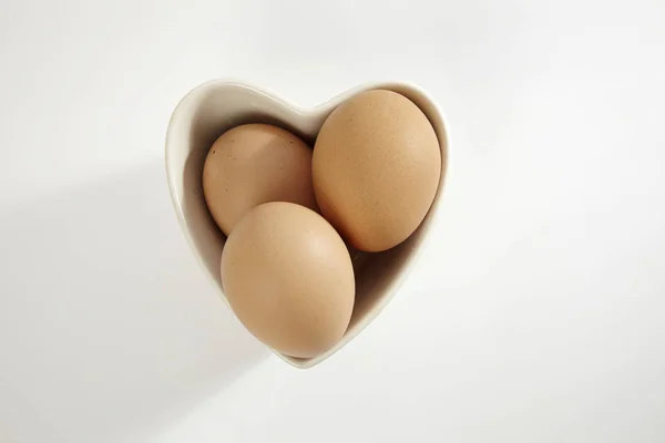 Ovos em forma de coração recipiente — Fotografia de Stock