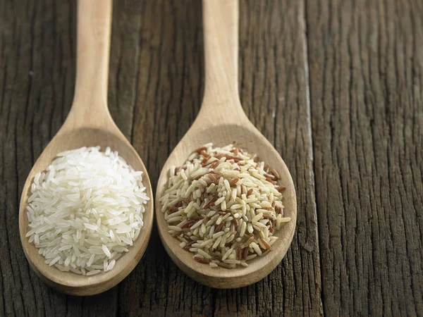 Raw rice in spoons — Stock Photo, Image