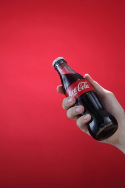 El tutma şişe Coca-Cola