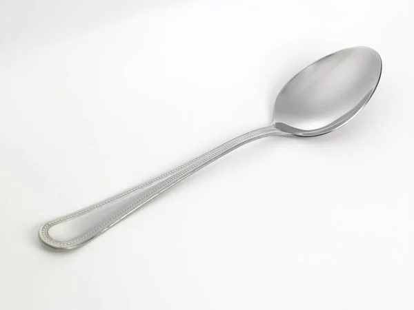 Cucchiaio su tavolo bianco — Foto Stock