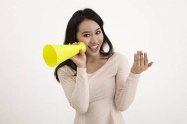 beyaz zemin üzerine sarı megafon kullanan malay kadın 