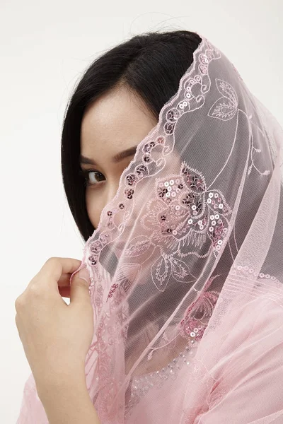 malay woman wearing pink baju kurung traditional clothes posing in studio