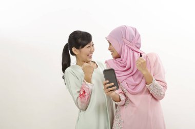 akıllı telefon olan iki mutlu genç Müslüman kadın