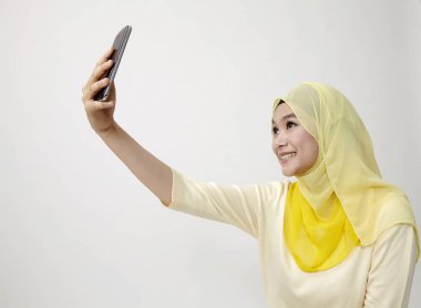 Malay kadın holding akıllı kullanarak telefon kendi kendine portre