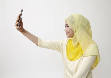 Malay kadın holding akıllı kullanarak telefon kendi kendine portre