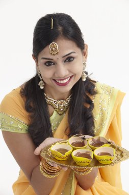 Göz alıcı geleneksel giyim kandil tutan Hintli kadın