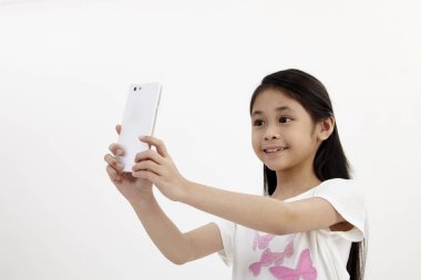 Çocukluk ve teknoloji. Akıllı telefon kullanan sevimli küçük kız. Beyaz izole.