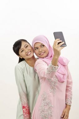 akıllı telefon olan iki mutlu genç Müslüman kadın