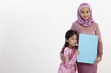 Anne ve kızı boş bir afişini holding