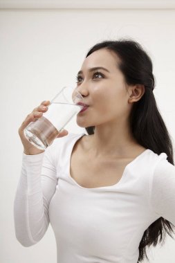 bir bardak su tutan malay kadın