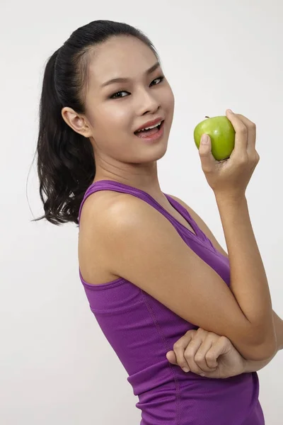 健康的漂亮的中国女孩在白色抱着一个绿色的苹果 — 图库照片