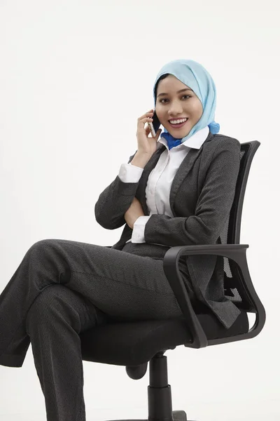 携帯電話を使用して話しているオフィスの椅子に座ってマレー ビジネス女性 — ストック写真