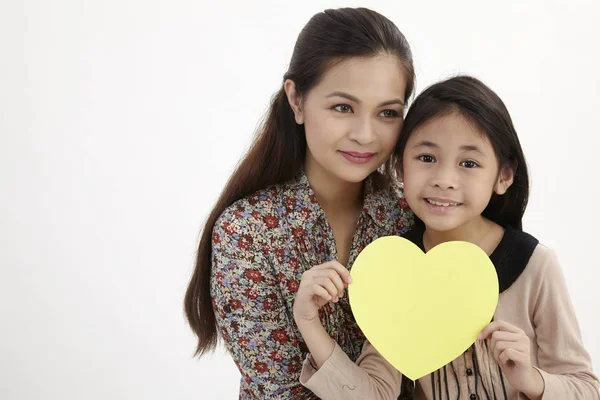 Madre Hija Sosteniendo Una Tarjeta Amarilla Blanco Con Forma Corazón —  Fotos de Stock