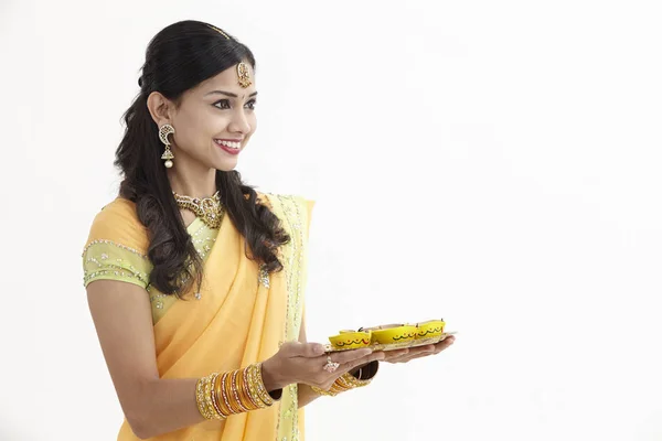 華やかな服の Diyas のトレイを持ってのインドの女性 — ストック写真